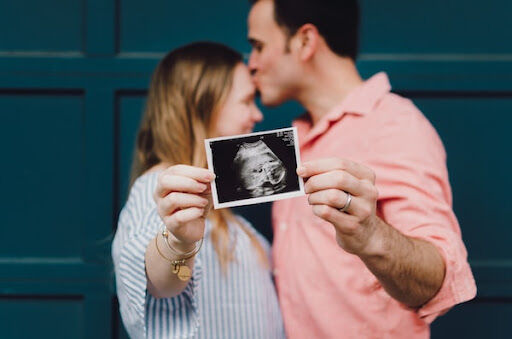 parents hold up an ultrasound photo Things To Do When Planning To Expand Your Family